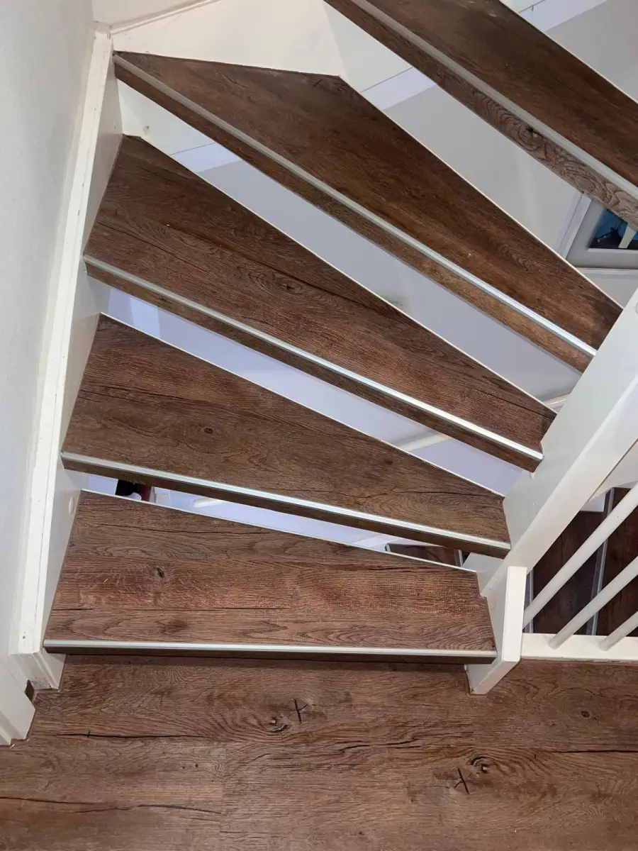 Renovierte Treppe mit passgenauem Holzdekor-Belag und Metallprofilen