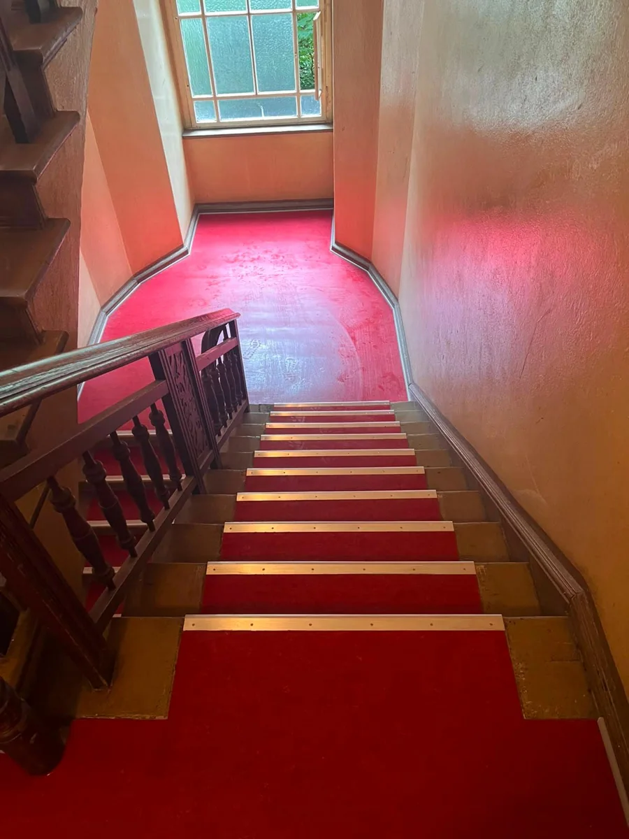 Roter Belag auf Treppe und Podest, Blick zum Fenster